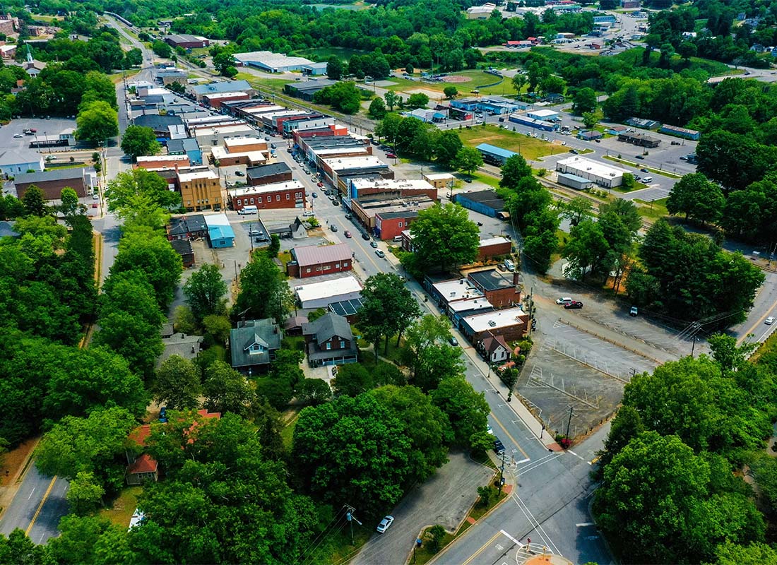 Kinston, NC - Aerial View of Buildings Surrounded by Bright Green Trees Along the Main Street in Kinston North Carolina on a Sunny Day